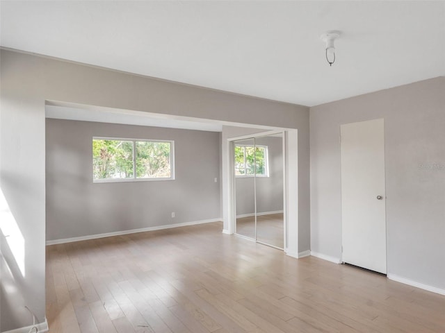 spare room featuring light hardwood / wood-style flooring and plenty of natural light