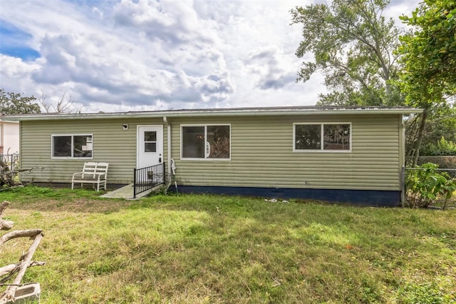 rear view of property with a lawn