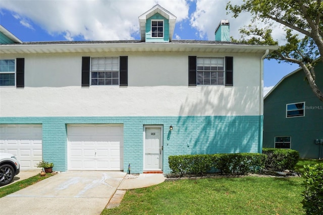 multi unit property with a garage and a front yard