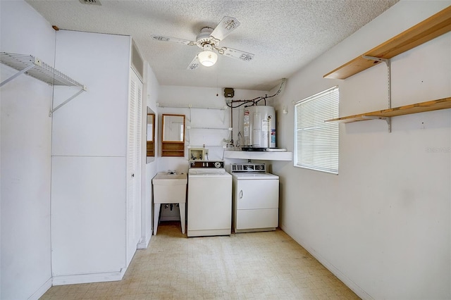 laundry room featuring sink, ceiling fan, a textured ceiling, independent washer and dryer, and water heater