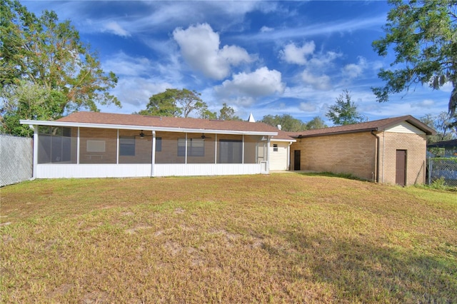 back of property featuring a lawn and a sunroom