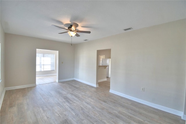 empty room with ceiling fan and light wood-type flooring