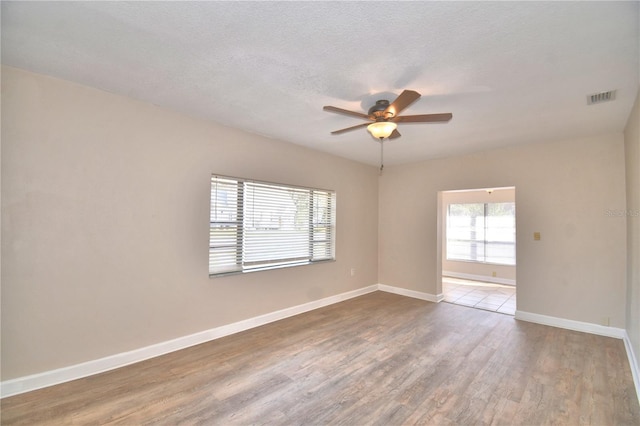 empty room featuring ceiling fan, hardwood / wood-style floors, and a textured ceiling