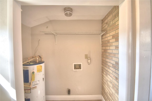 clothes washing area with hookup for an electric dryer, washer hookup, electric water heater, and brick wall