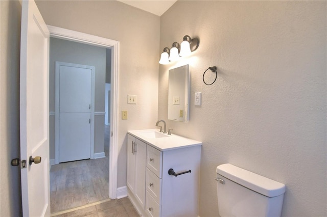 bathroom with vanity, hardwood / wood-style flooring, and toilet