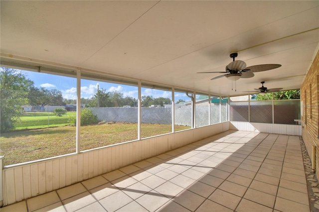 unfurnished sunroom featuring ceiling fan