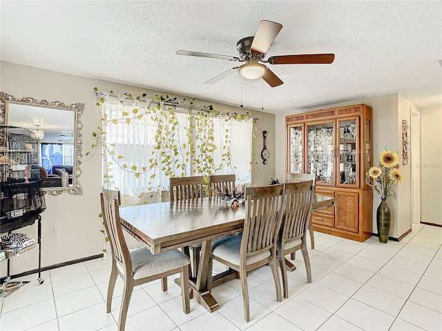 dining space with ceiling fan, light tile patterned flooring, and a textured ceiling