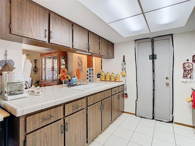 kitchen featuring sink, light tile patterned floors, and tile counters