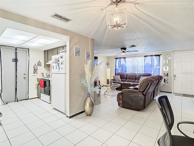 living room featuring ceiling fan with notable chandelier and a textured ceiling