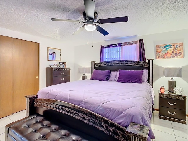 tiled bedroom featuring ceiling fan and a textured ceiling