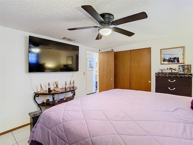 tiled bedroom featuring a textured ceiling, a closet, and ceiling fan