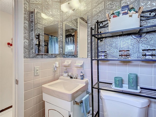 bathroom with vanity, a shower with shower curtain, tile walls, and toilet