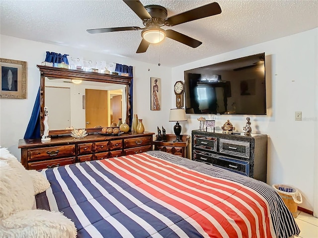 tiled bedroom featuring ceiling fan and a textured ceiling