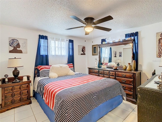 tiled bedroom with ceiling fan and a textured ceiling