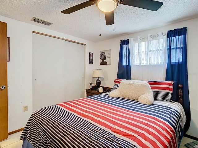 bedroom with ceiling fan, a closet, and a textured ceiling