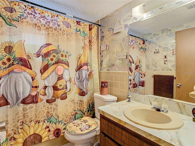 bathroom featuring vanity, a textured ceiling, and toilet