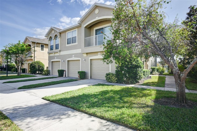 multi unit property with a garage, a front yard, and a balcony