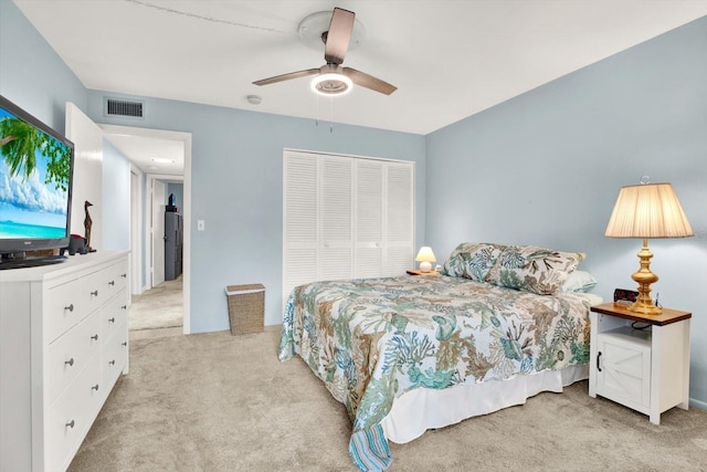 carpeted bedroom with ceiling fan and a closet