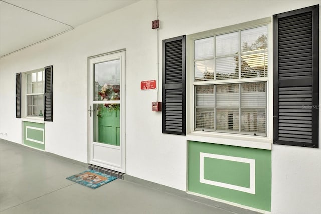 view of exterior entry featuring stucco siding