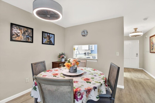 dining space with light wood-style flooring and baseboards