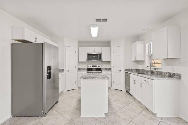 kitchen featuring sink, white cabinets, stainless steel appliances, and a center island