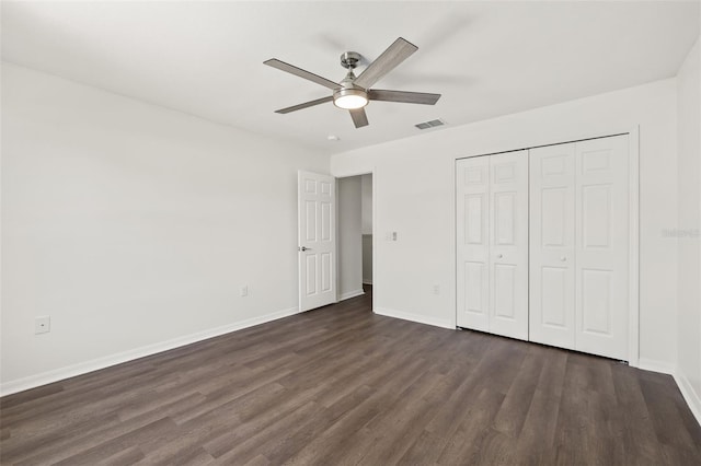 unfurnished bedroom with dark hardwood / wood-style flooring, a closet, and ceiling fan