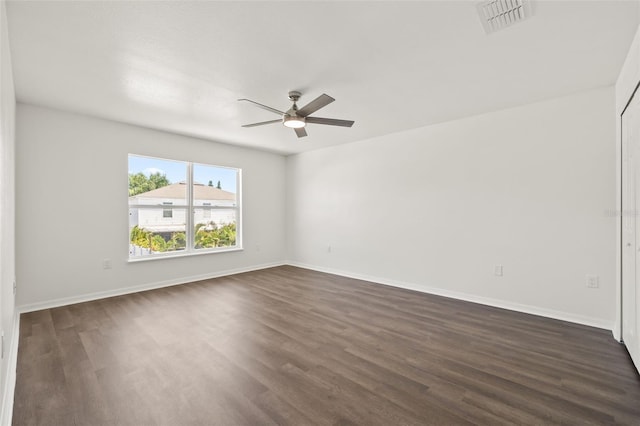 empty room featuring dark wood-type flooring and ceiling fan