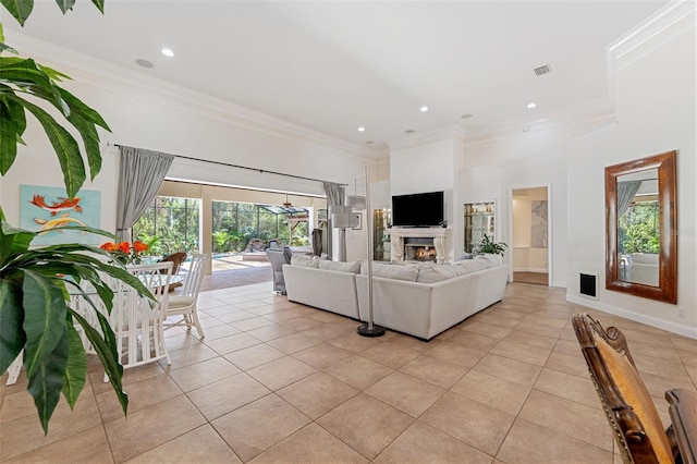 living room with a healthy amount of sunlight, crown molding, and light tile patterned flooring