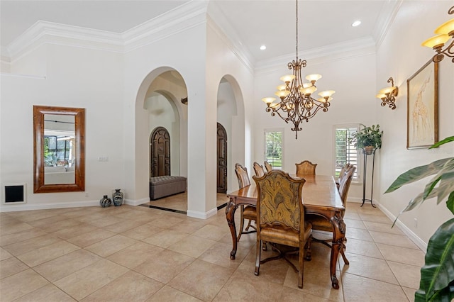 tiled dining area featuring a towering ceiling, a notable chandelier, and crown molding