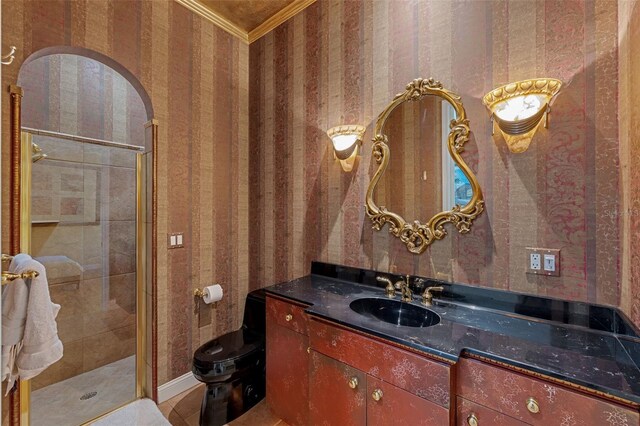 bathroom with tile patterned floors, toilet, ornamental molding, vanity, and walk in shower