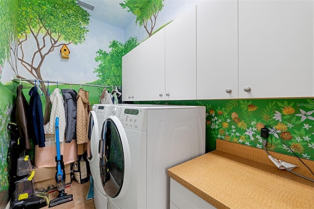 washroom with cabinets and washer and dryer