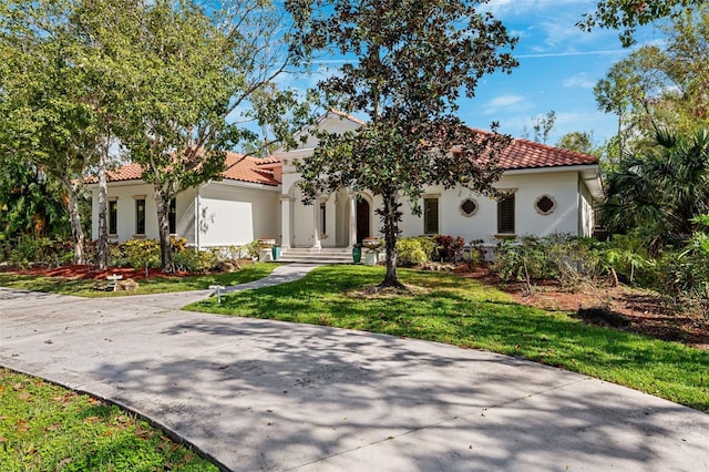 mediterranean / spanish home featuring a front lawn