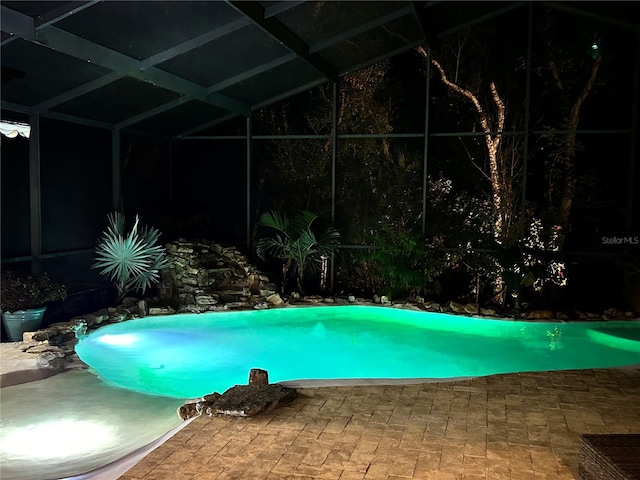 view of swimming pool with glass enclosure and a patio area