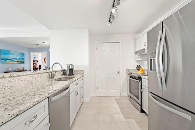 kitchen with light stone counters, appliances with stainless steel finishes, white cabinets, sink, and rail lighting