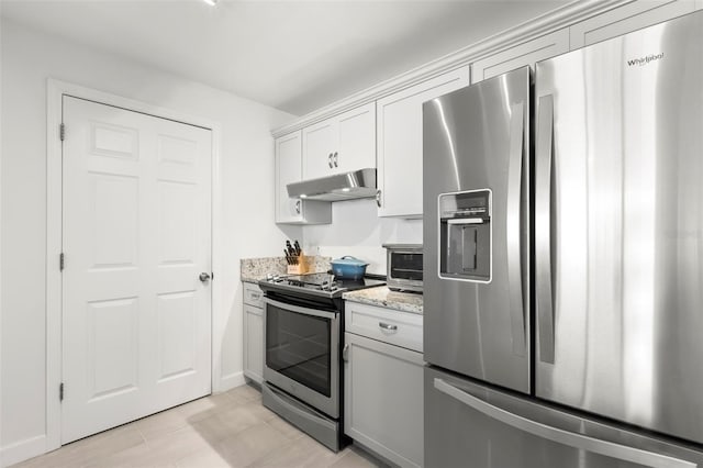 kitchen featuring white cabinets, light stone counters, and appliances with stainless steel finishes