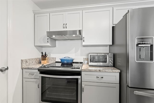 kitchen with white cabinets, appliances with stainless steel finishes, and light stone countertops