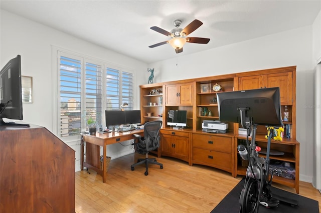 office with light wood-type flooring and ceiling fan