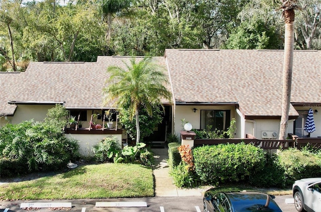2920 Star Apple Ct, Palm Harbor, FL 34684 - view of front facade with uncovered parking, a shingled roof, and stucco siding