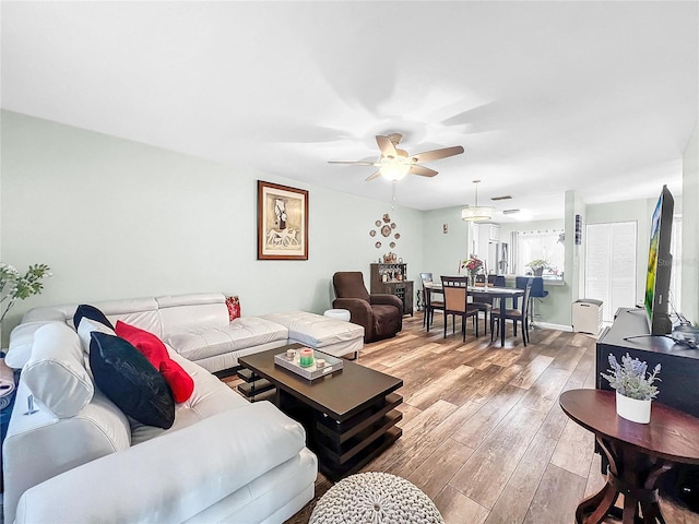 living room with light hardwood / wood-style floors and ceiling fan