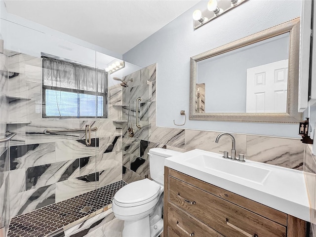 bathroom with a shower with door, vanity, toilet, and tile walls