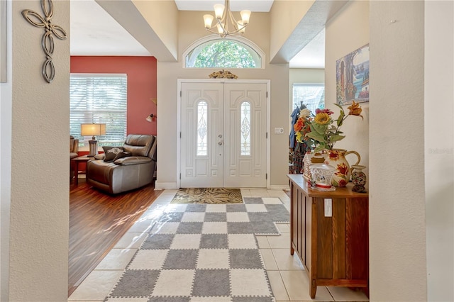 foyer entrance with an inviting chandelier and light tile patterned floors