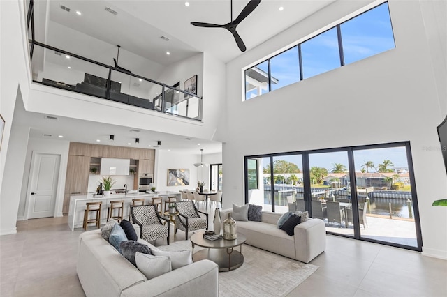 living room with a towering ceiling and ceiling fan