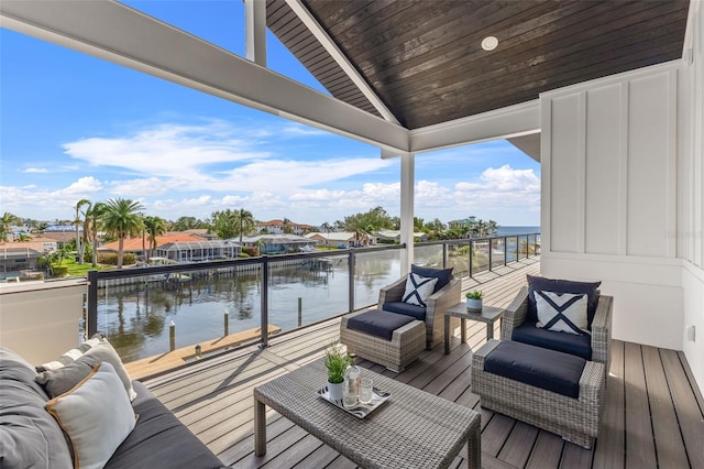 dock area with an outdoor living space, a balcony, and a water view