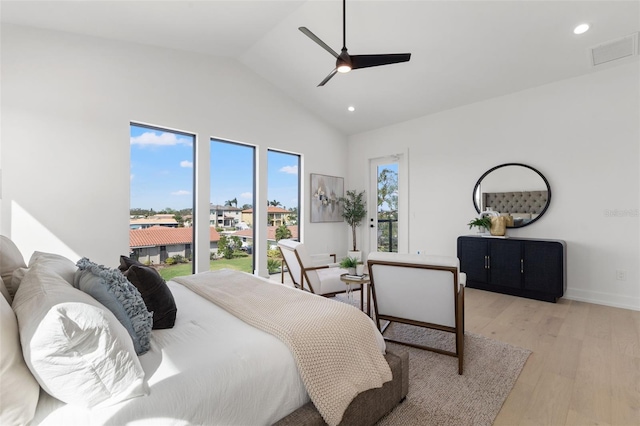 bedroom with ceiling fan, lofted ceiling, multiple windows, and light hardwood / wood-style flooring