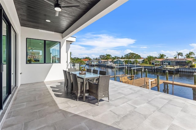 view of patio / terrace with a water view, a dock, and ceiling fan