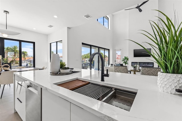 kitchen with white cabinets, visible vents, and a sink