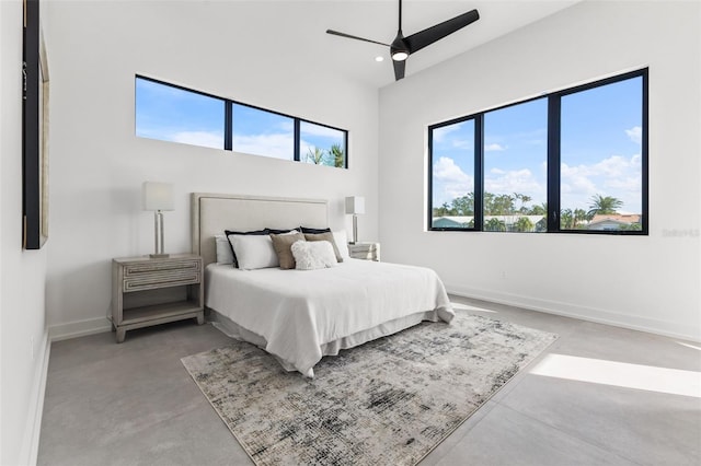 bedroom with multiple windows, concrete flooring, and baseboards