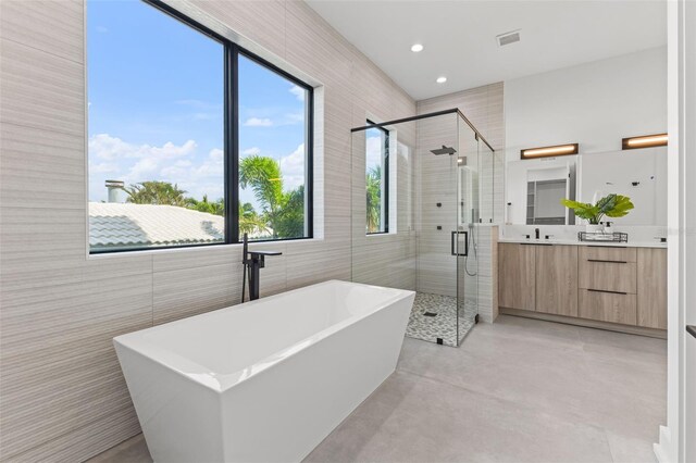 full bath featuring visible vents, a stall shower, concrete floors, a soaking tub, and vanity