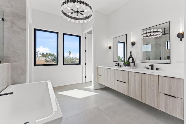 bathroom featuring double vanity, a shower with shower door, a freestanding tub, and a sink