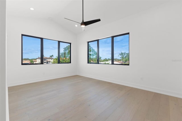 unfurnished room with light wood-style flooring, baseboards, a ceiling fan, and vaulted ceiling